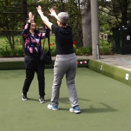 Councillor Lily Chenge high fives Chrystal Shepherd, two-time Canadian women's pairs champion, during opening day at Willowdale Lawn Bowling Club. 